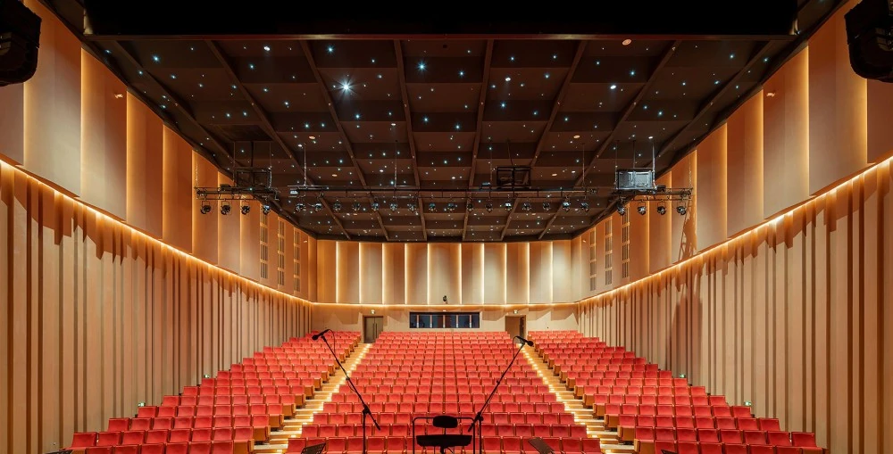 Twelve Kiva II, flown in two hangs of six either side of the stage, all but vanish against the room’s dark surfaces while delivering wide, even coverage to every seat