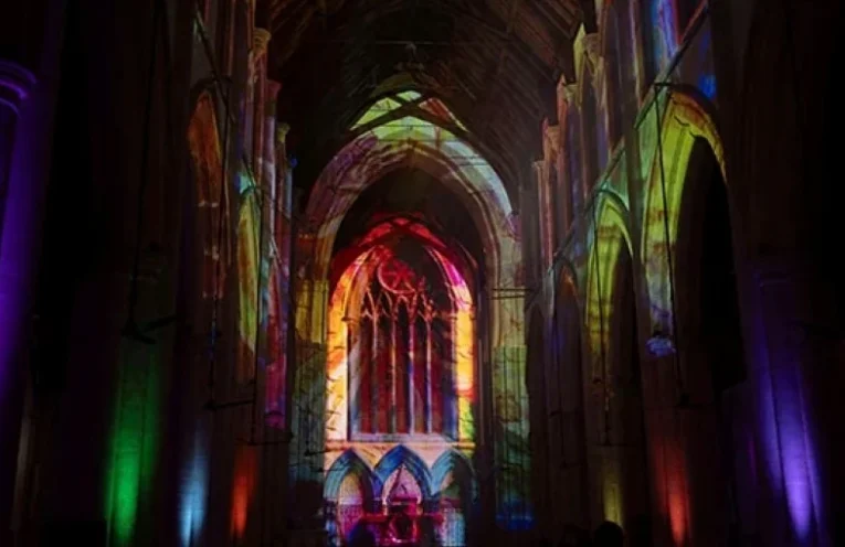 Truss-mounted projectors displayed Earth-to-cosmos visuals across the church’s soaring arches, vaulted ceilings and stained-glass windows