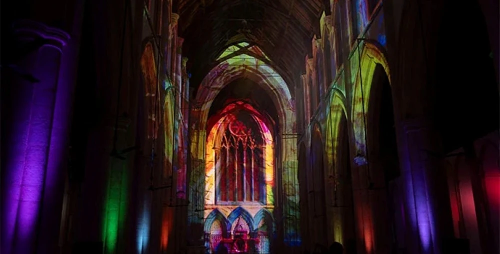 Truss-mounted projectors displayed Earth-to-cosmos visuals across the church’s soaring arches, vaulted ceilings and stained-glass windows